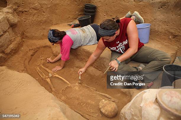American archaeology students uncover and clean a human skeleton found on the site of the first Philistine cemetery ever found , Ashkelon National...