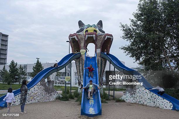 Visitors play on a slide at the National Amusement Park, known as the Children's Park, in Ulaanbaatar, Mongolia, on Wednesday, July 13, 2016. The...