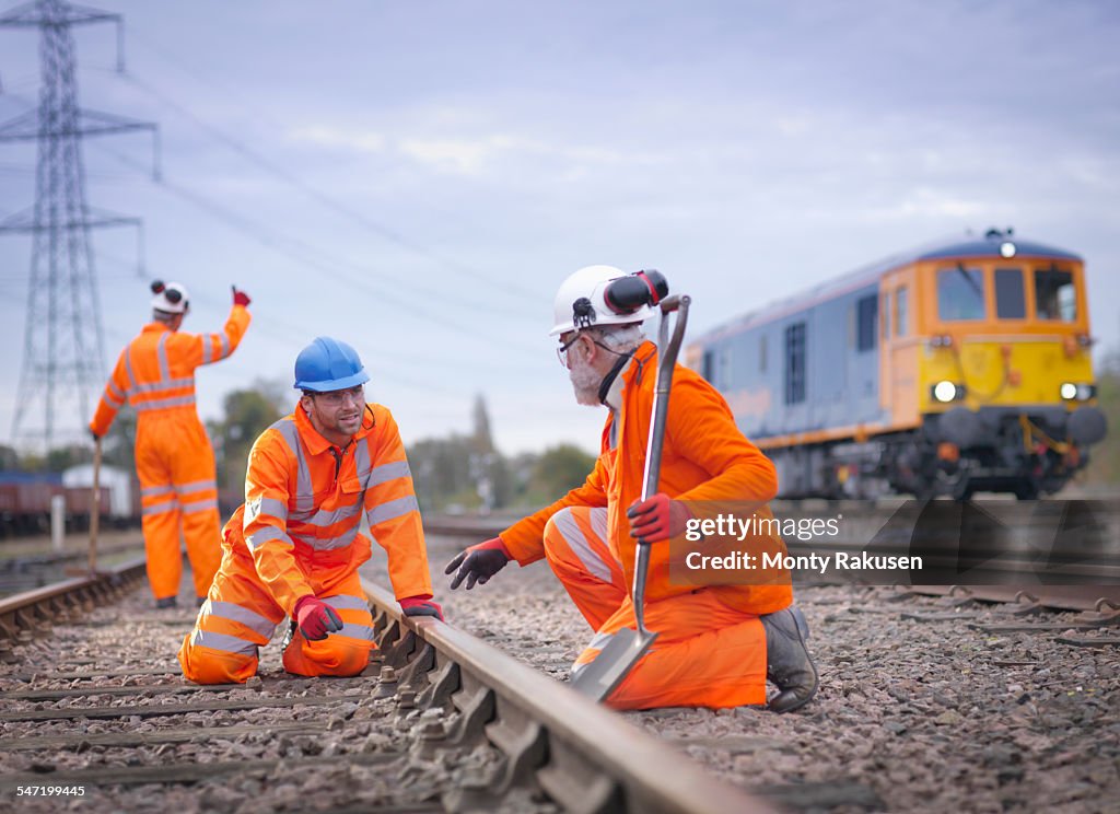 Apprentice railway worker instructed by engineer on railway