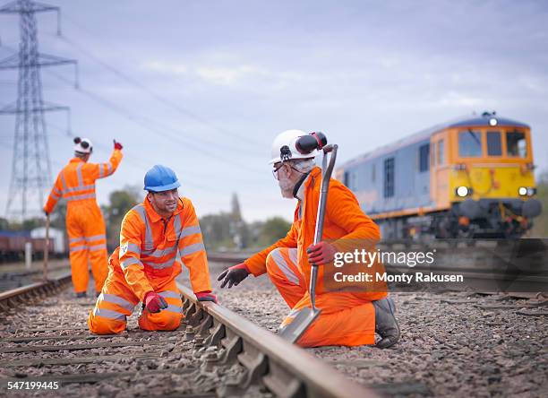 apprentice railway worker instructed by engineer on railway - wagon photos et images de collection