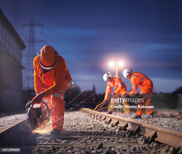 railway maintenance workers using grinder on track at night - railroad track bildbanksfoton och bilder