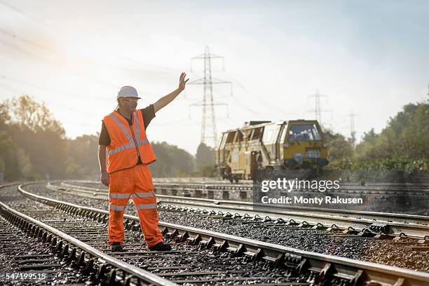 rail worker signalling to maintenance train on railway - rail worker stock pictures, royalty-free photos & images