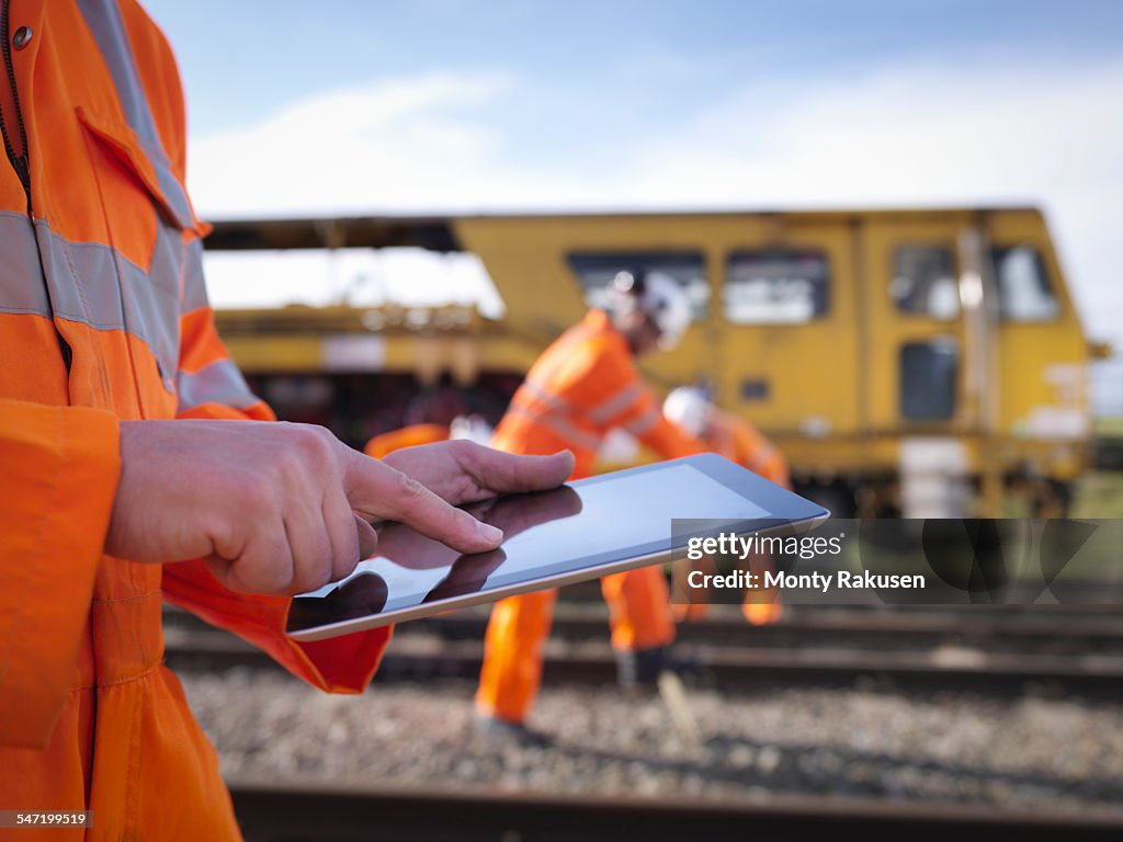 Railway maintenance worker using digital tablet, close up