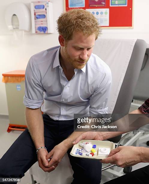 Prince Harry is shown the negative result of his HIV test taken by Specialist Psychotherapist Robert Palmer as visits Burrell Street Sexual Health...