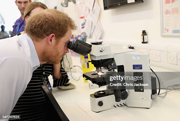 Prince Harry looks through a microscope at a sample of gonorrhoea as he visits Burrell Street Sexual Health Clinic on July 14, 2016 in London,...