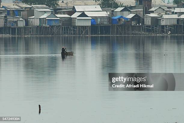 crossing the pluit reservoir - jakarta slum stock pictures, royalty-free photos & images