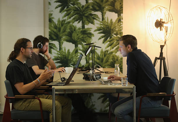 People work at computers in the community space of Factory Berlin on July 14, 2016 in Berlin, Germany. Factory Berlin is a commercial space that has...