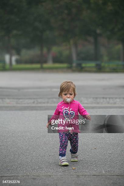 a cute young baby learning to walk with pacifier - feet sucking stock pictures, royalty-free photos & images