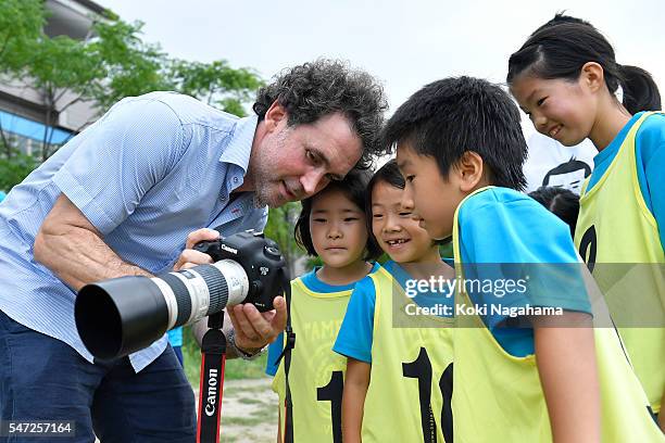 Getty Images photographer Adam Pretty talkas to children during his track and field class for children 'Tamesue College Running Club' at Toyosu MAGIC...