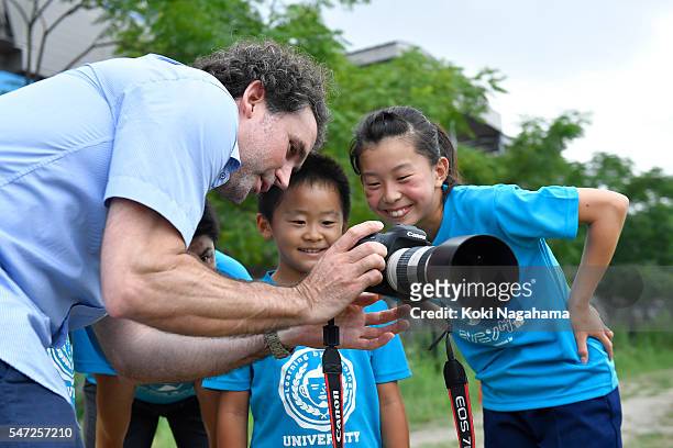 Getty Images photographer Adam Pretty talkas to children during his track and field class for children 'Tamesue College Running Club' at Toyosu MAGIC...
