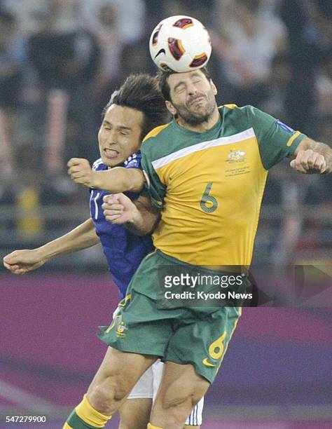 Qatar - Japan's Ryoichi Maeda and Australia's Sasa Ognenovski compete for the ball during the first half of the Asian Cup soccer final in Doha on...