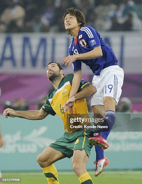 Qatar - Japan's Tadanari Lee and Australia's Sasa Ognenovski compete for the ball during the first half of extra time of the Asian Cup soccer final...