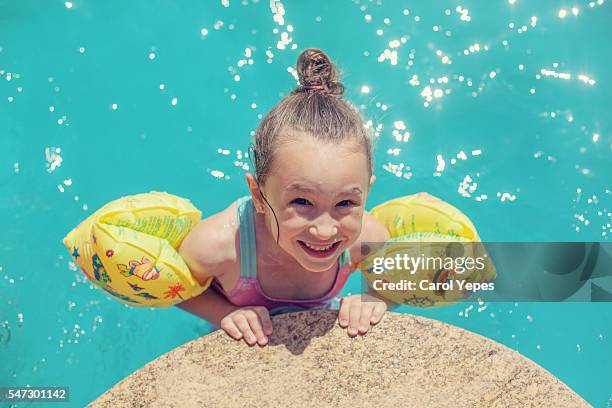 happy young girl wearing water wings - tube girl stock-fotos und bilder