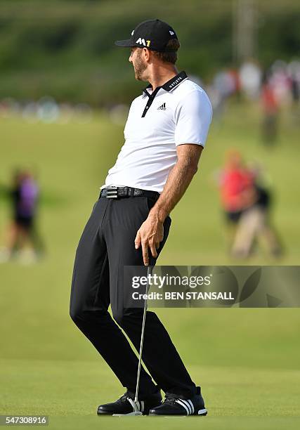 Golfer Dustin Johnson reacts to missing his putt on the 12th Green during his first round on the opening day of the 2016 British Open Golf...