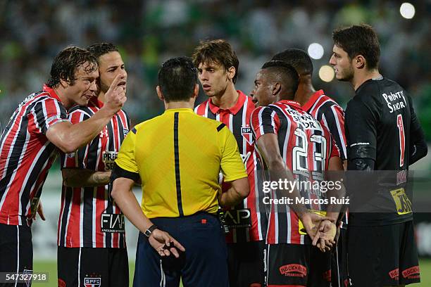 Diego Lugano of Sao Paulo and teammates argue with referee Patricio Polic during a second leg semi final match between Atletico Nacional and Sao...