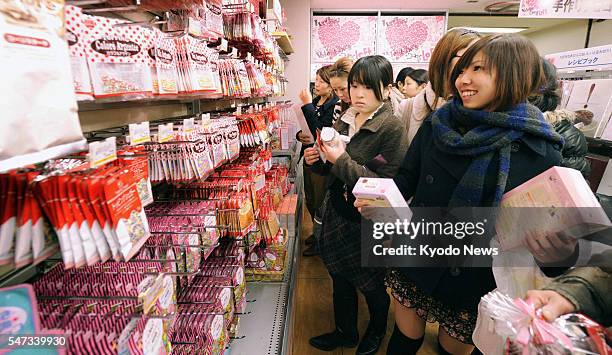 Japan - Young women choose decorative items for Valentine's Day chocolates at a store in Musashino, Tokyo, on Feb. 13 the eve of the gift-giving day....