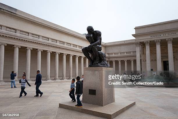 In the courtyard of the Legion of Honor art museum in the Lands End neighborhood of San Francisco, children play near The Thinker, a bronze statue by...