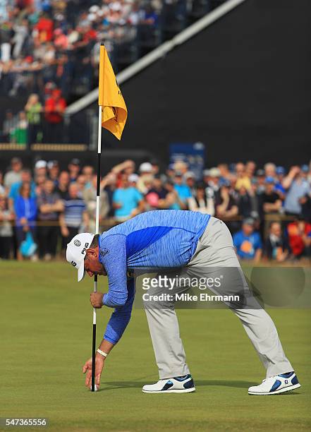 Lee Westwood of England collects his ball after an eagle on the 16th hole during the first round on day one of the 145th Open Championship at Royal...