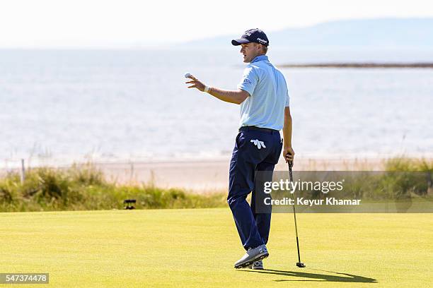 Russell Knox of Scotland waves his ball to fans after making a birdie putt on the fifth hole green during the first round on day one of the 145th...