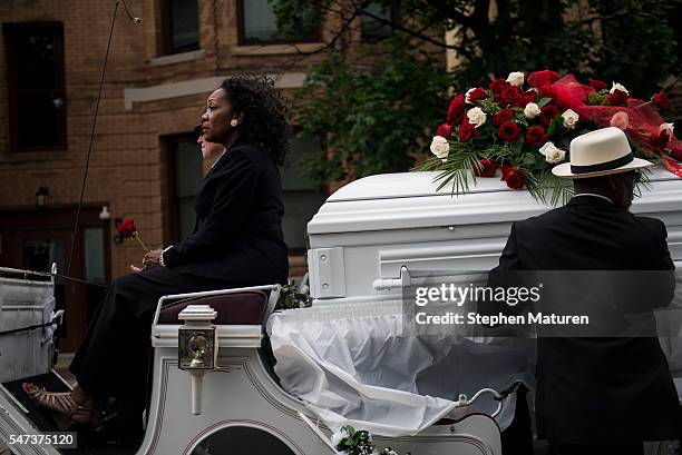 Woman holds a rose while riding in a horse drawn carriage carrying the casket of Philando Castile after his funeral at the Cathedral of St. Paul on...