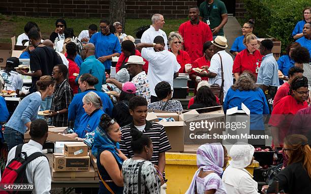 Volunteers from St. Paul Public Schools serve food to guests outside J.J. Hill Montessori School on July 14, 2016 in St. Paul, Minnesota. The meal...