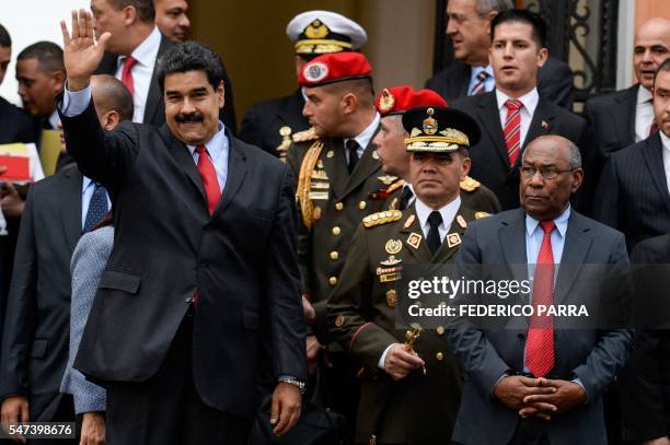 Venezuelan President Nicolas Maduro waves next to Defence Minister Padrino Lopez and Vice-President Aristobulo Isturis during a ceremony to...
