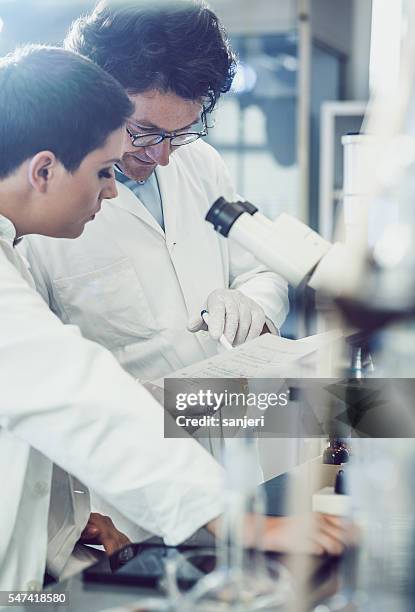 scientist using microscope in the laboratory - clinical laboratory stock pictures, royalty-free photos & images