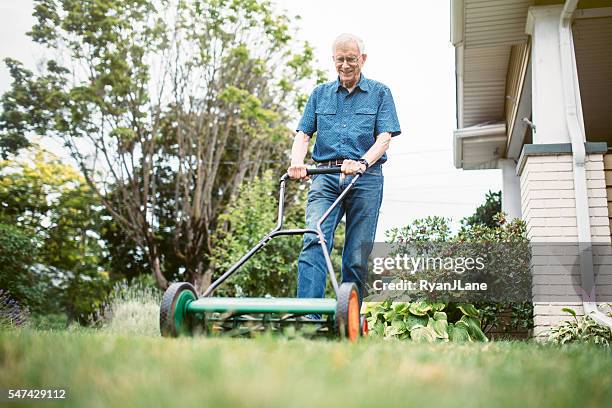 senior adult man doing yardwork - handgrasmaaier stockfoto's en -beelden