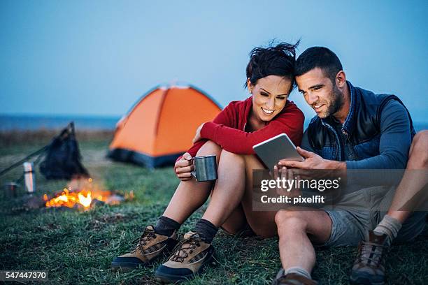 campers with digital tablet - mountains dusk stock pictures, royalty-free photos & images