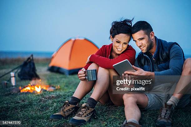 campers with digital tablet - young couple hiking stock pictures, royalty-free photos & images