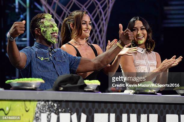 Player Emmanuel Sanders and professional wrestlers Nikki Bella and Brie Bella participate in a key slime pie eating contest onstage during the...