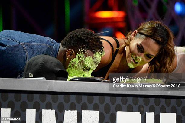 Player Emmanuel Sanders and professional wrestler Nikki Bella participate in a key slime pie eating contest onstage during the Nickelodeon Kids'...