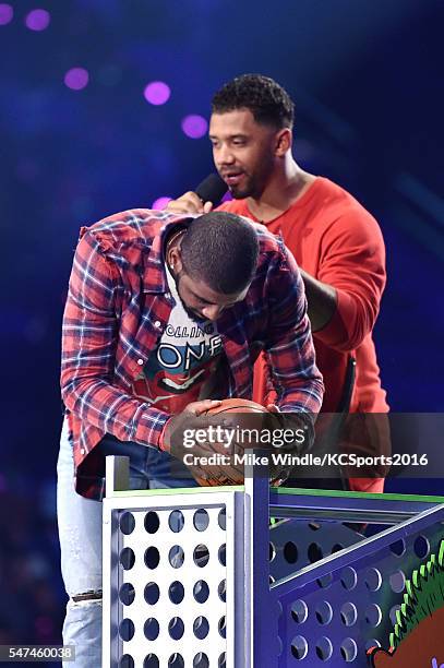 Player Kyrie Irving and host Russell Wilson speak onstage during the Nickelodeon Kids' Choice Sports Awards 2016 at UCLA's Pauley Pavilion on July...