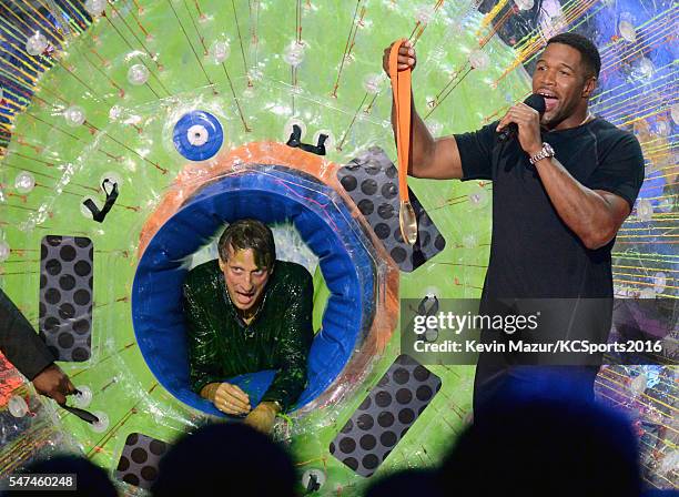 Professional skateboarder Tony Hawk speaks with TV personality/former NFL player Michael Strahan after being slimed onstage during the Nickelodeon...