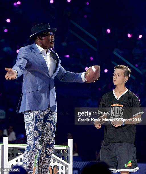 Player Cam Newton and soccer player Jake Lombardo participate in the $50K Triple Shot Challenge onstage during the Nickelodeon Kids' Choice Sports...