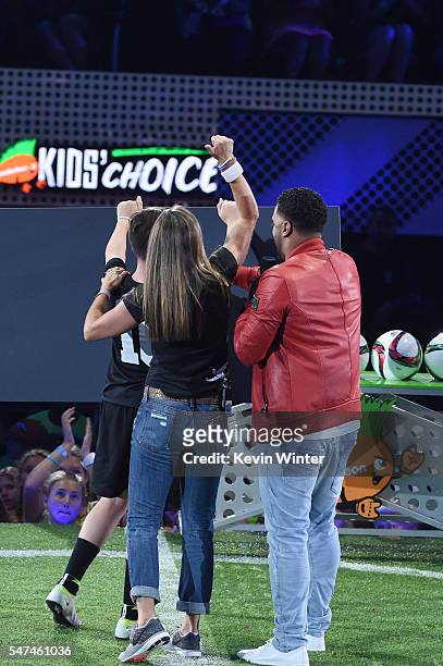 Retired soccer player Brandi Chastain, $50K Triple Shot contestant Oliver Callanan, and host Russell Wilson react as a check is presented during a...