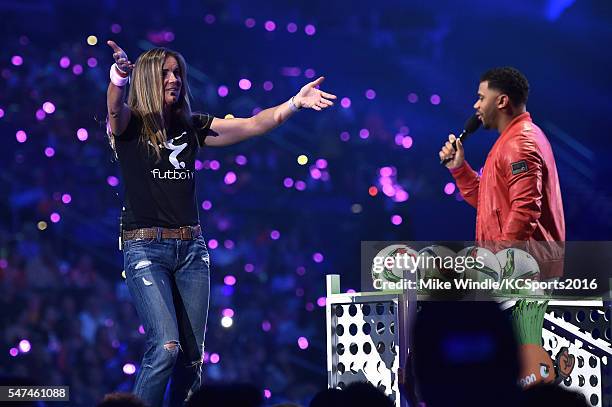 Retired soccer player Brandi Chastain and host Russell Wilson speak onstage during the Nickelodeon Kids' Choice Sports Awards 2016 at UCLA's Pauley...