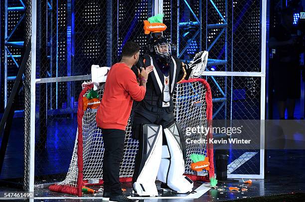 Host Russell Wilson and TV personality Nick Cannon participate in a game onstage during the Nickelodeon Kids' Choice Sports Awards 2016 at UCLA's...