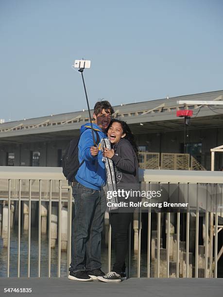 People using selfie stick on the pier in San Francisci