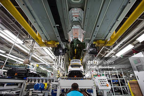 An employee monitors the installation of a battery pack into a Hyundai Motor Co. Ioniq electric vehicle on the production line at the company's plant...