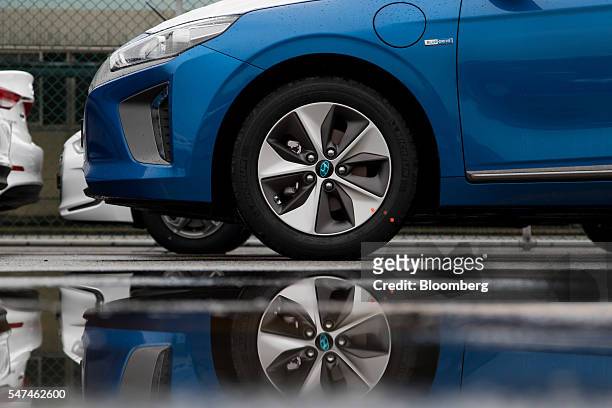 Hyundai Motor Co. Ioniq electric vehicle is reflected in a puddle at the company's plant in Ulsan, South Korea, on Monday, July 4, 2016. South Korea...