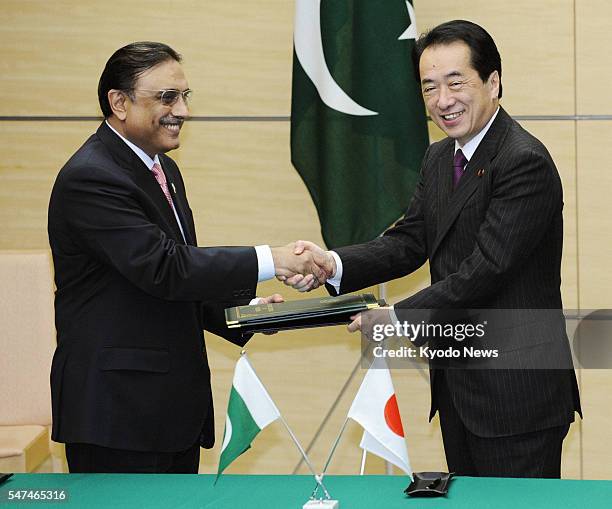 Japan - Japanese Prime Minister Naoto Kan and Pakistani President Asif Zardari shake hands after exchanging documents at the prime minister's office...