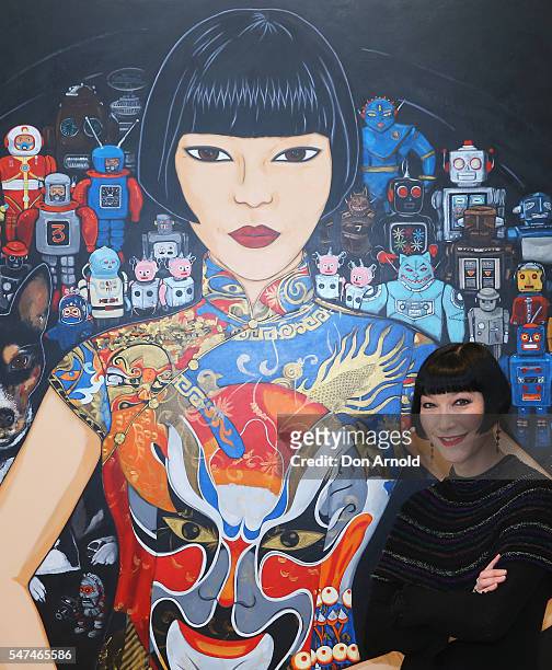 Claudia Chan Shaw poses in front of Katte Beynon's portrait of Claudia titled 'Claudia, Spartacus and the robots' at the winners announcement for the...