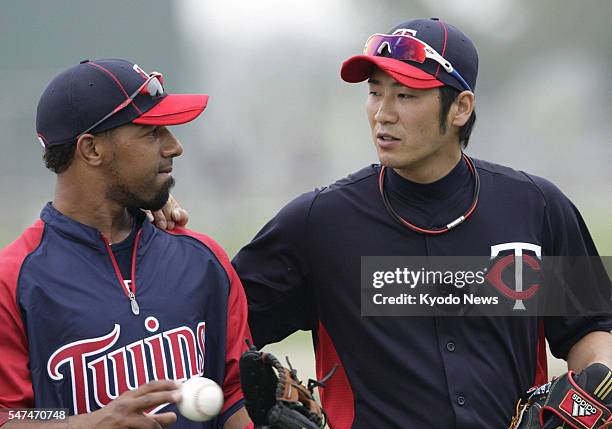 United States - Japanese infielder Tsuyoshi Nishioka of the Minnesota Twins chats with Alexi Casilla after playing catch at the team's training camp...