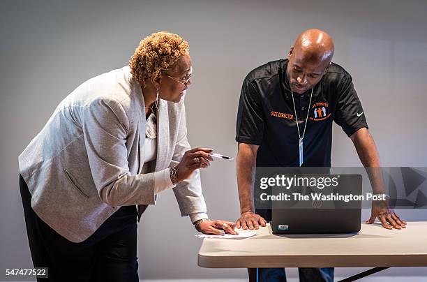 Safe Streets Director Dedra Layne, left, and Site Director Imhotep Fatiu, discuss some new training materials after the session. Safe Streets staff...