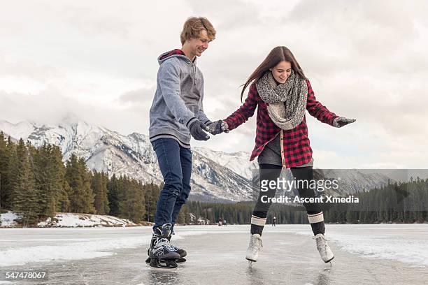 teen couple skate on lake, boy provides assistance - all that skate 2014 stock pictures, royalty-free photos & images