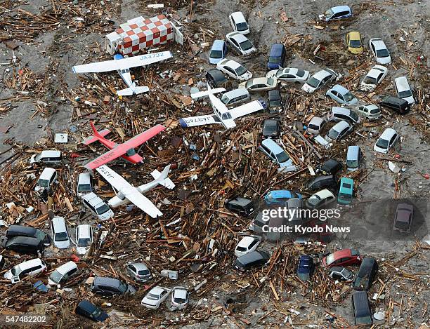 Japan - Airplanes and cars are covered with debris at Sendai airport in Miyagi Prefecture, northeastern Japan, on March 11 after a tsunami following...