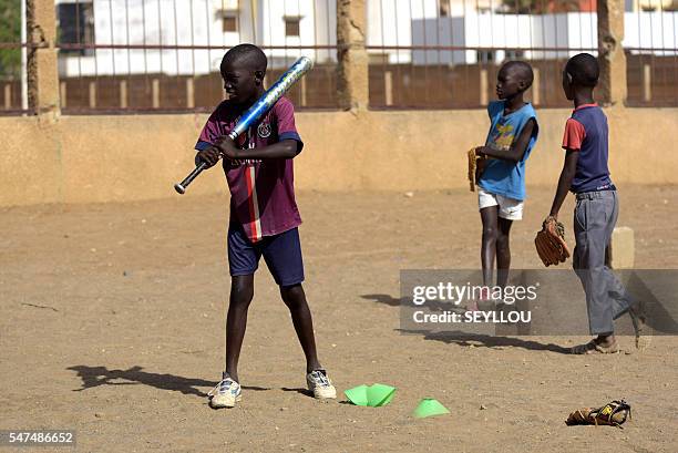 Picture taken on July 14, 2016 shows young Senegalese children playing baseball, on an improvised baseball pitch installed by a Japanese aid worker...