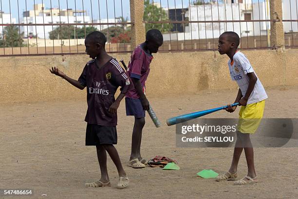 Picture taken on July 14, 2016 shows young Senegalese children playing baseball, on an improvised baseball pitch installed by a Japanese aid worker...