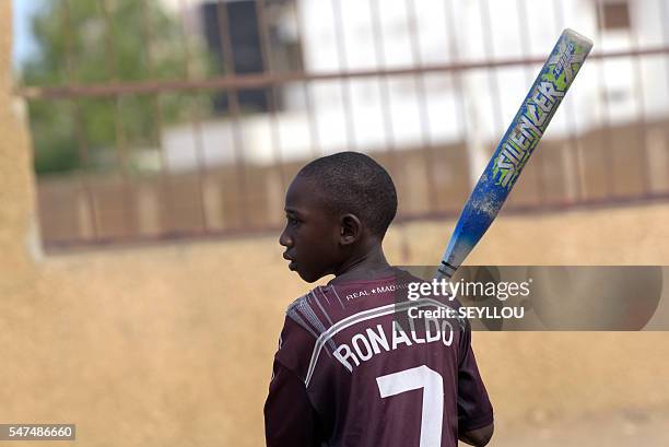 Picture taken on July 14, 2016 shows young Senegalese children playing baseball, on an improvised baseball pitch installed by a Japanese aid worker...